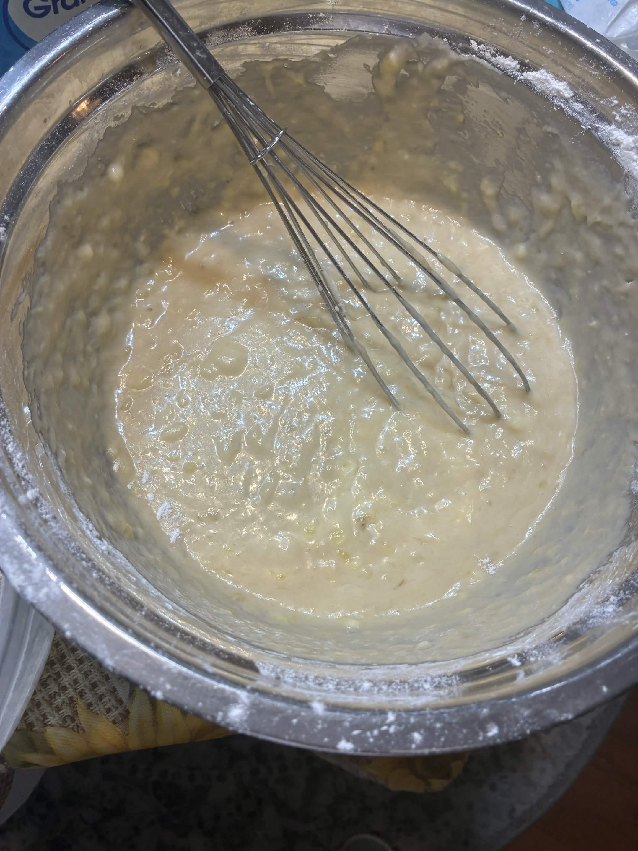 Banana bread batter being mixed in a bowl.